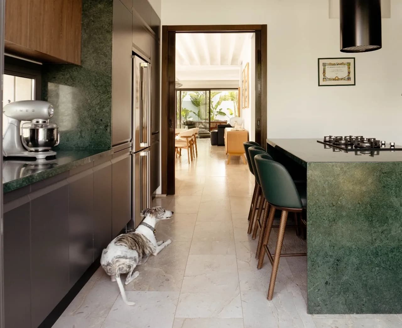 Cuisine contemporaine Cuisina avec îlot en pierre verte, rangements en bois et espace ouvert lumineux.